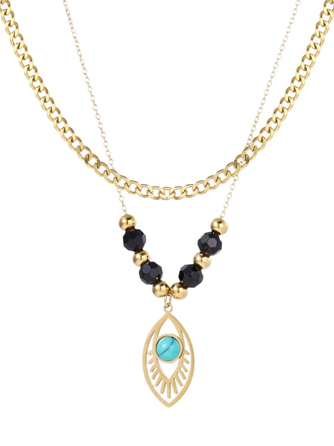 Layered gold necklace with turquoise evil eye pendant and black quartz beads on cream background